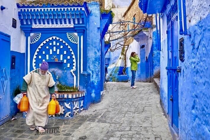 Group tours in Morocco. Local man carries water from the well. Chefchaouen, Morocco