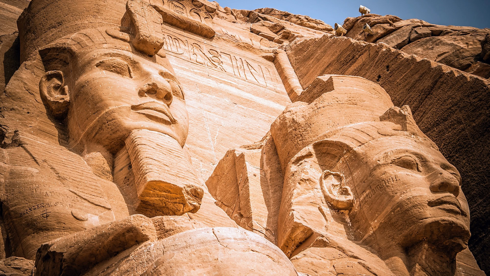 Colossal pharaoh statues at Abu Simbel temple complex carved into rock face