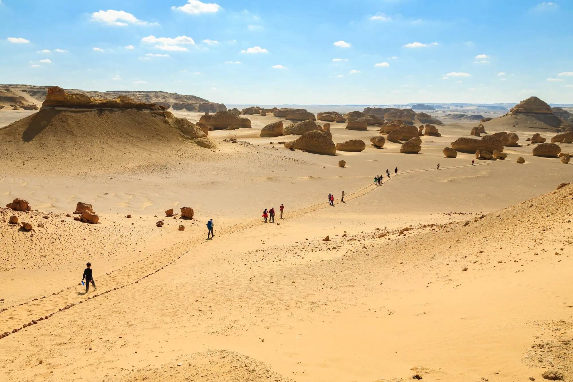 White rock formations rising from sand dunes in Egypt's White Desert