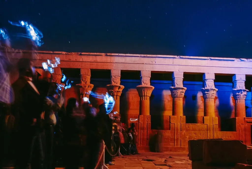 Night view of Philae Temple during light and sound show with visitors photographing