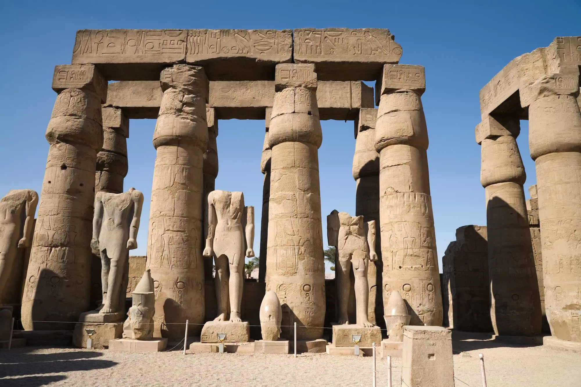 Ancient stone columns with hieroglyphic carvings at Karnak Temple's Great Hypostyle Hall