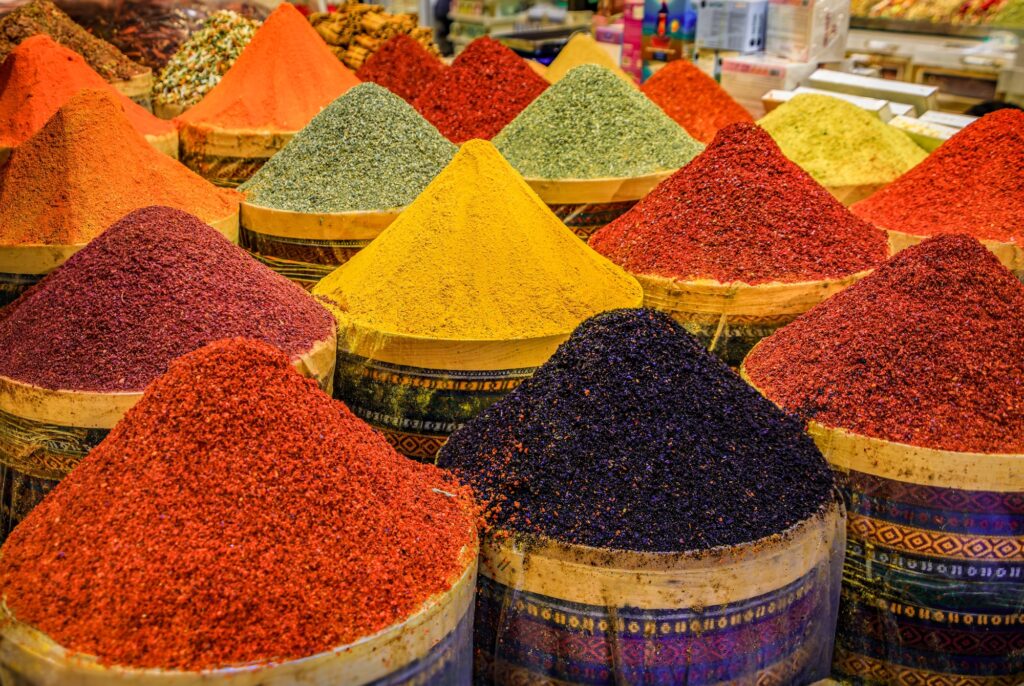 A vibrant display of bright orange paprika and other colorful spices in buckets at a bustling bazaar market trade and food culture Istanbul Turkey