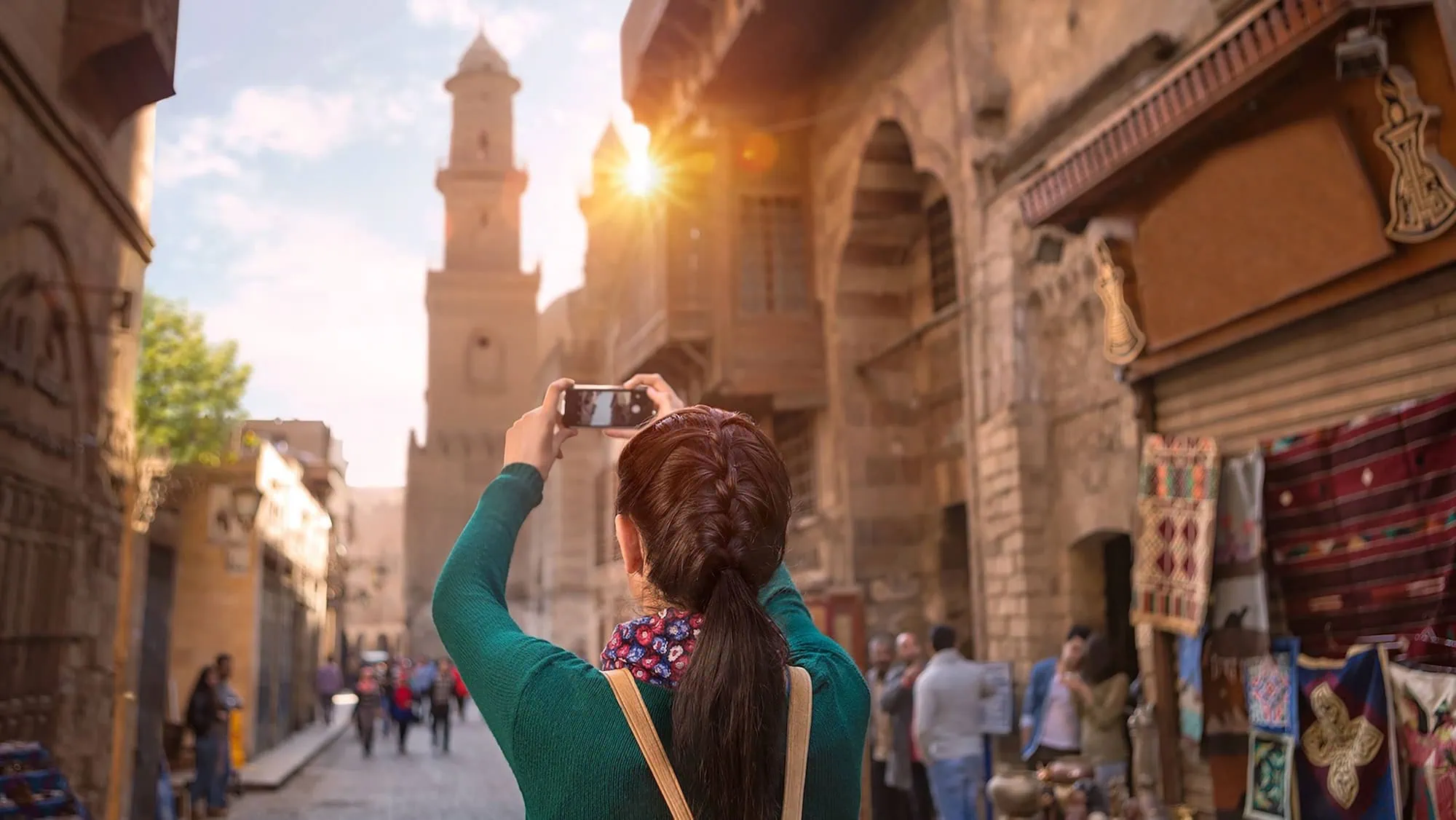 Tourist with smartphone exploring historic Islamic Cairo district with traditional architecture