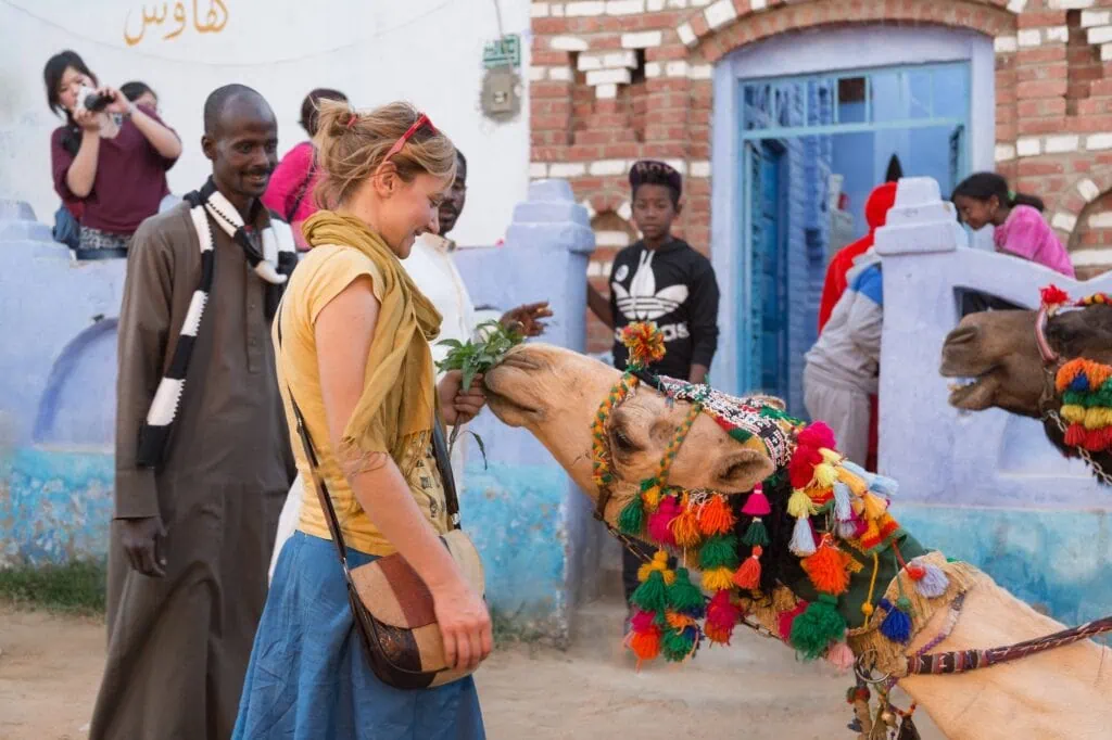 Tourist feeding a camel in a Nubian village