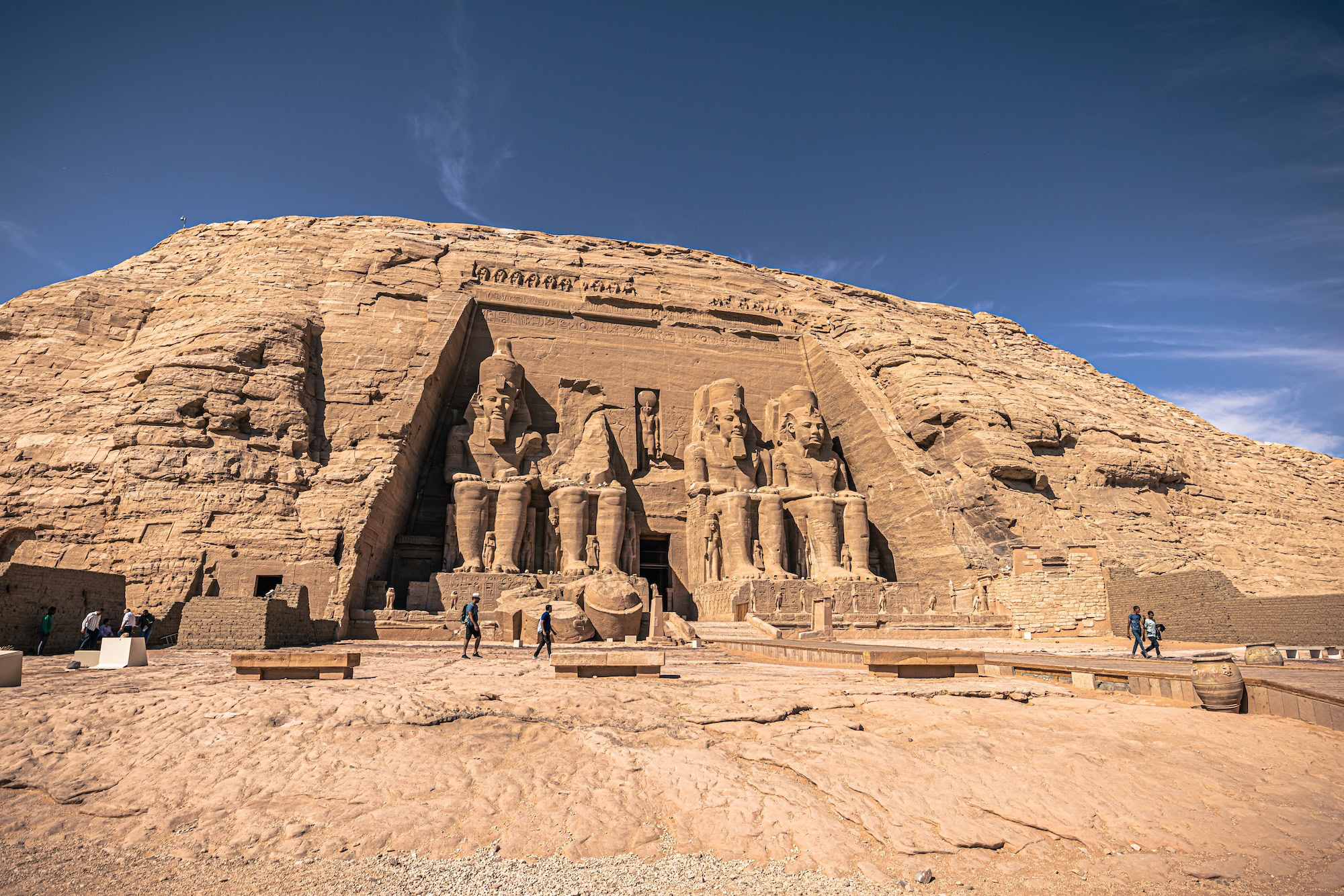 Majestic Abu Simbel Temple facade with colossal pharaoh statues and tourists at entrance