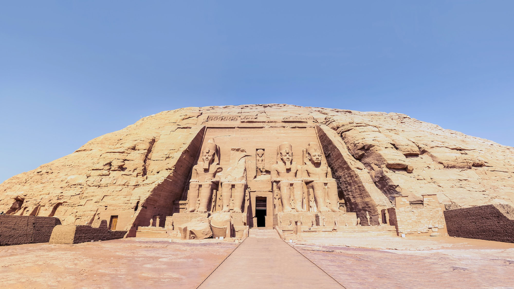 Abu Simbel Great Temple facade with four massive seated statues of Ramesses II carved into sandstone cliff