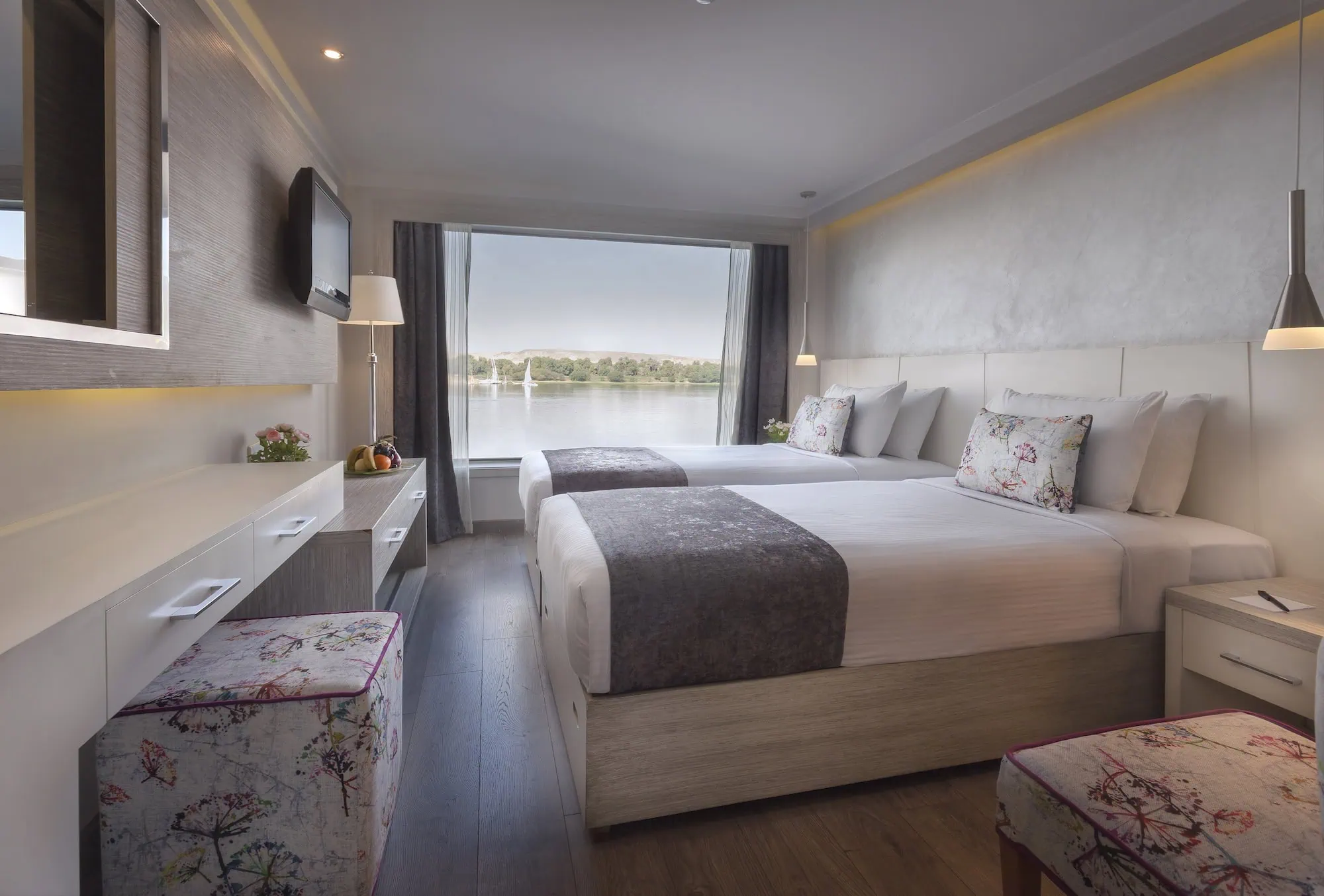 A cabin on a Luxury Nile Cruise vessel with twin beds and a window overlooking the Nile, the five-star accommodation on the Luxor to Aswan sailing.
