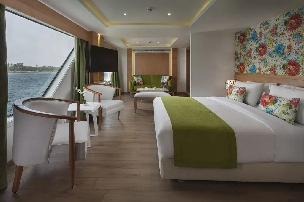 Spacious luxury suite with seating area and large windows on MS Amarco Nile cruise ship, Luxor