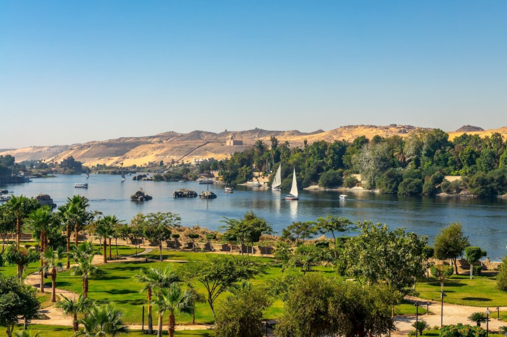 A scenic view of the Nile River with feluccas, the traditional wooden sailboats of Egypt