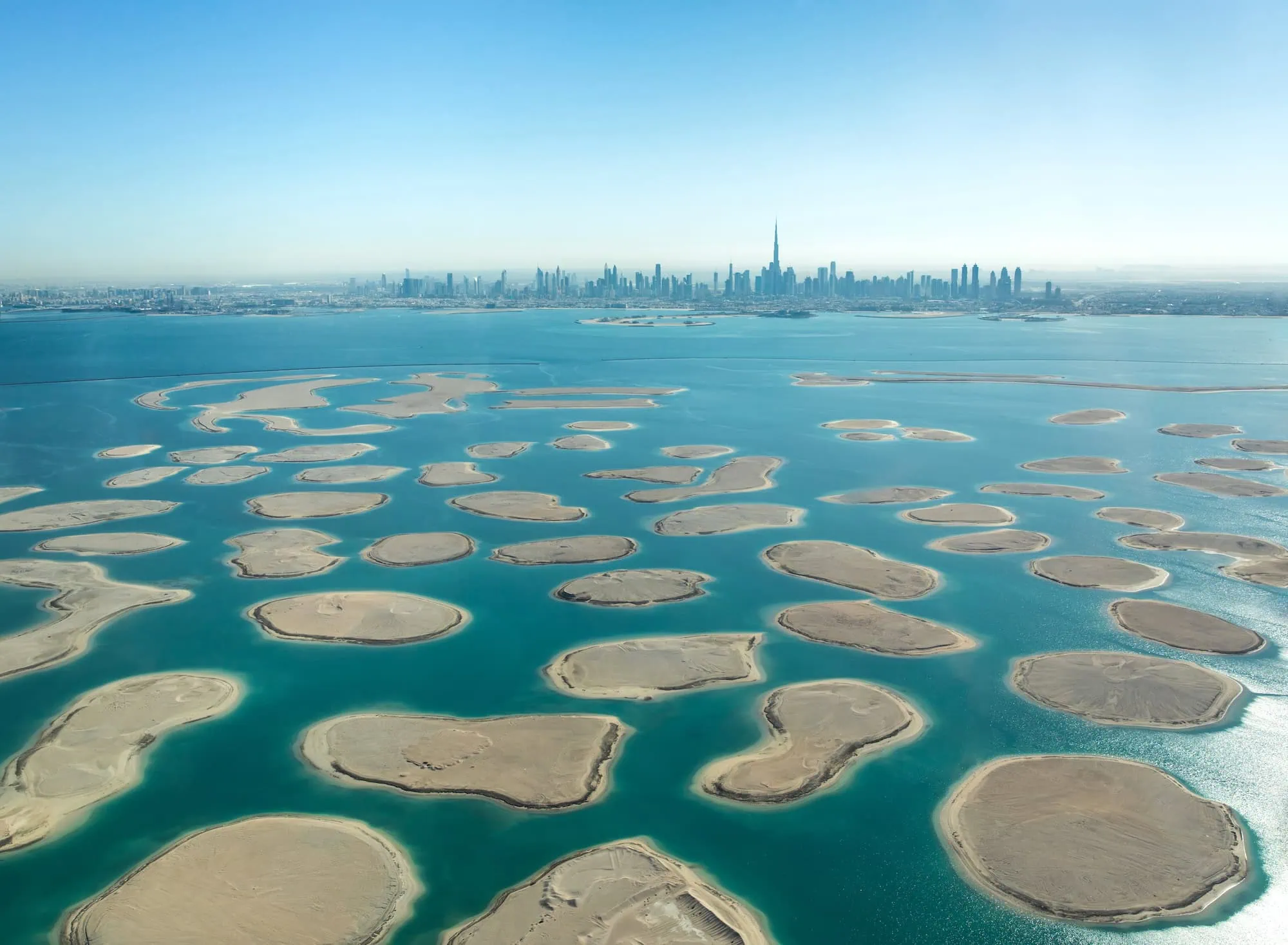 Aerial view of Dubai's World Islands with turquoise waters and downtown skyline