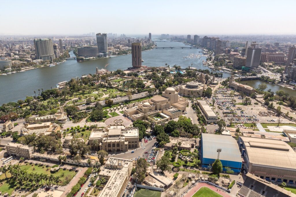 Aerial view of urban districts lining the Nile River with bridges and riverbanks, Cairo