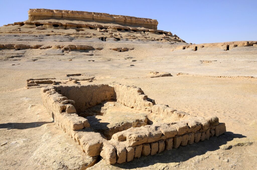 Rock-cut burial chambers and painted tomb entrances at Al Muzawaka Tombs in the desert landscape of Dakhla Oasis, Dakhla Oasis