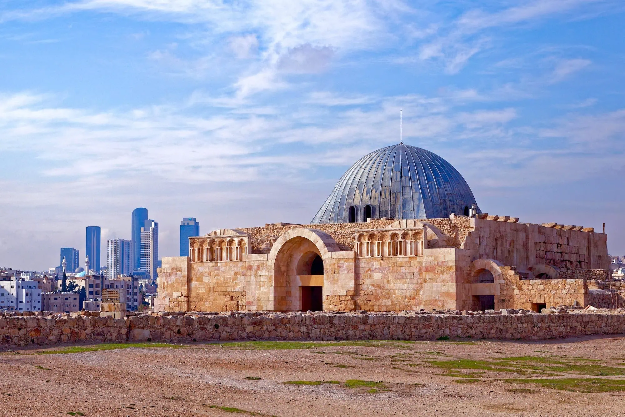 Ancient Umayyad Palace dome ruins at Amman Citadel with modern city skyline
