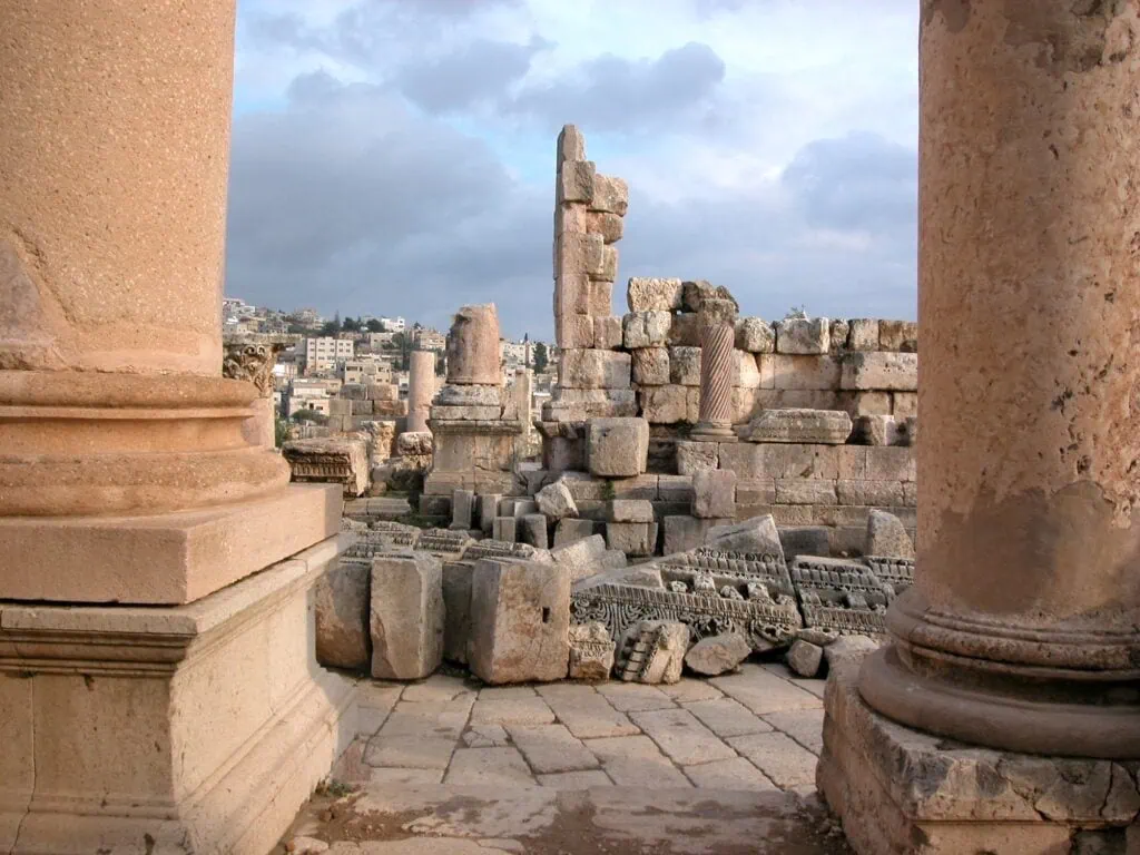 Massive limestone blocks and partially preserved Hellenistic palace structure set in a rural valley at Qasr Al-Abd, Amman
