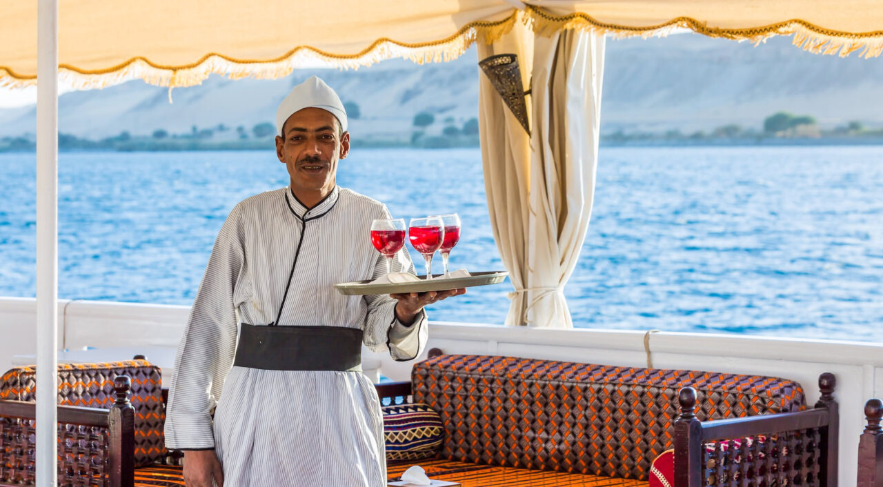 Waiter on MS Amoura Dahabiya deck overlooking the Nile