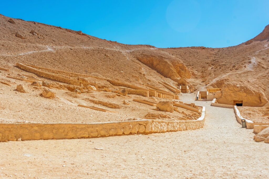 Rock-cut tomb entrances set into desert cliffs at the Valley of the Queens, Luxor