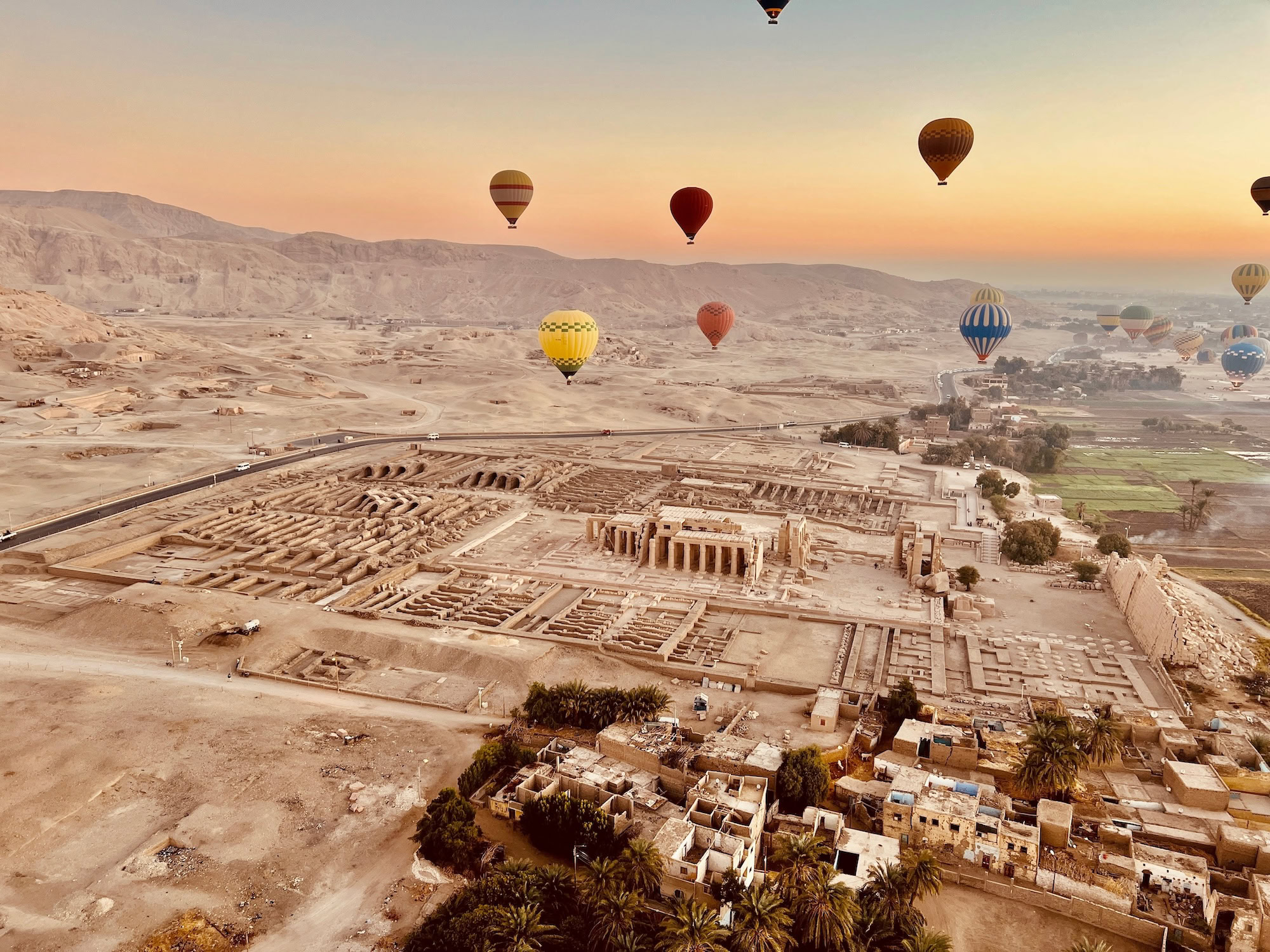 Aerial view of Medinet Habu Temple ruins with hot air balloons floating overhead