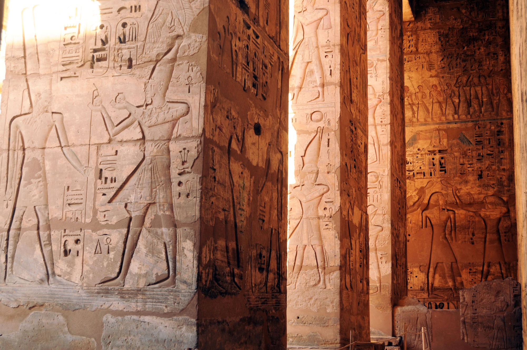 Templo egípcio com hieróglifos detalhados e figuras de faraós nas paredes de pedra