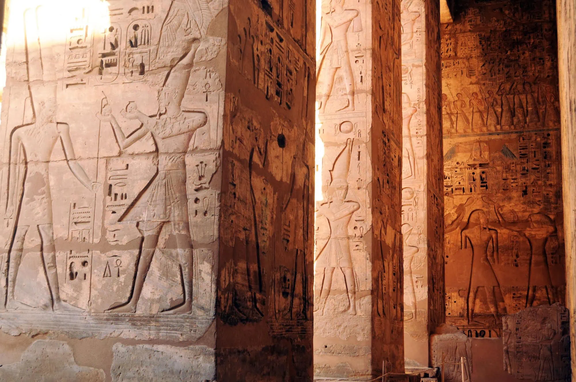 Templo egípcio com hieróglifos detalhados e figuras de faraós nas paredes de pedra