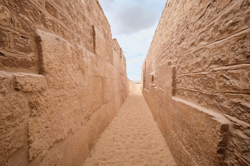 Stone mastaba walls and carved limestone blocks within the Saqqara Necropolis, Saqqara