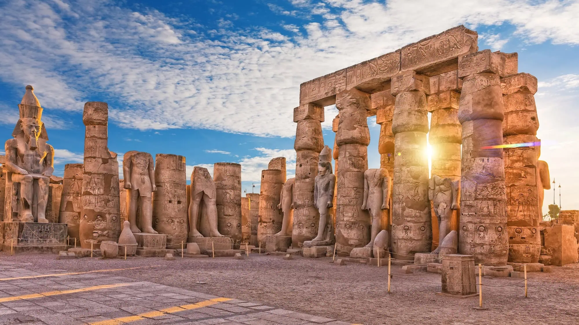 Majestic Luxor Temple with ancient columns, pharaoh statues, and hieroglyphs under dramatic sky
