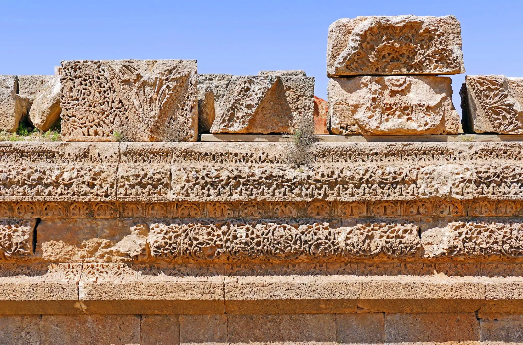 Ancient Umayyad carved limestone wall ruins showing intricate Islamic decorative stonework at Qasr Al-Mshatta in Jordan