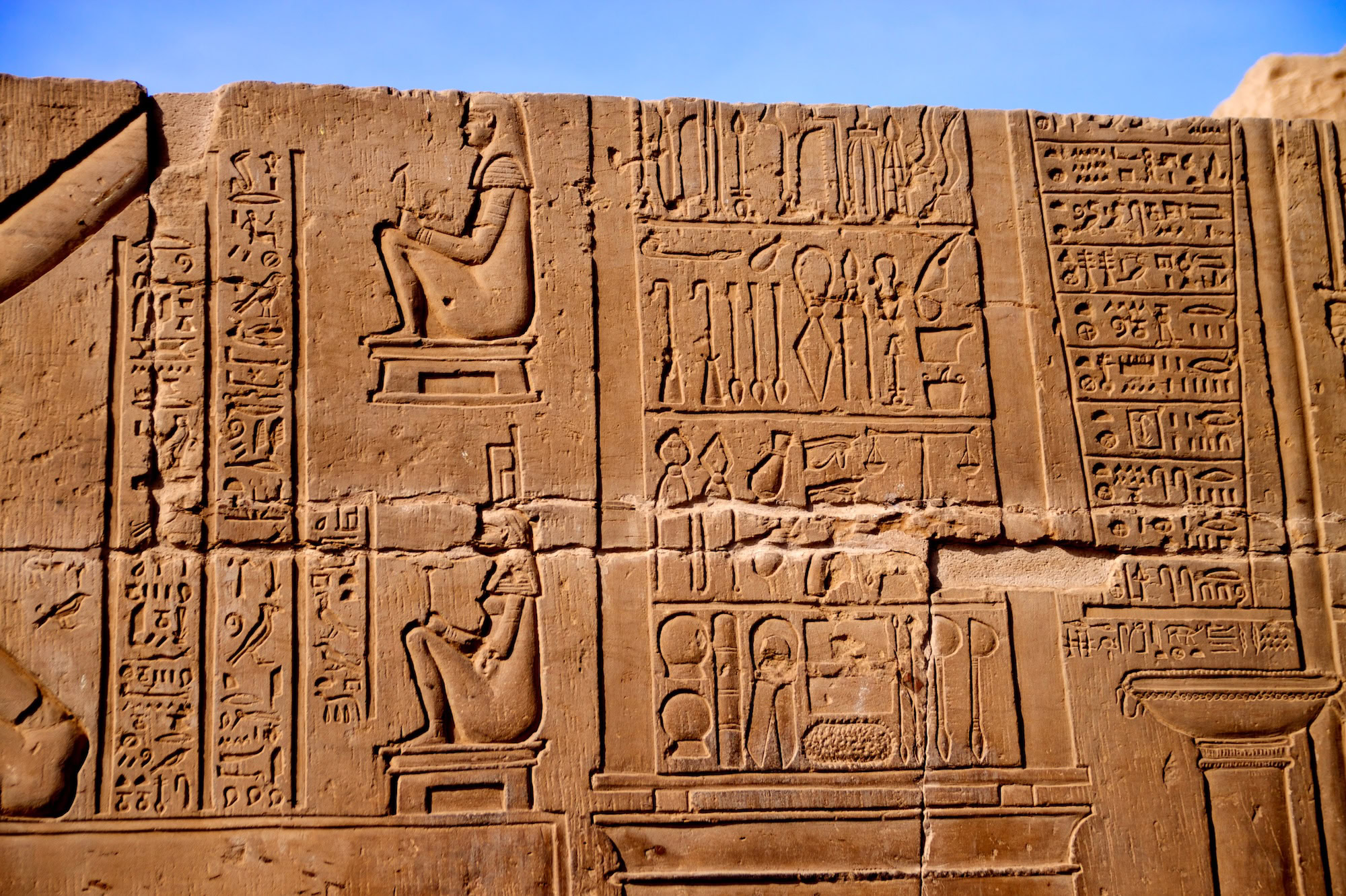 Geroglifici egiziani antichi con figure di faraone e divinità scolpite nella pietra