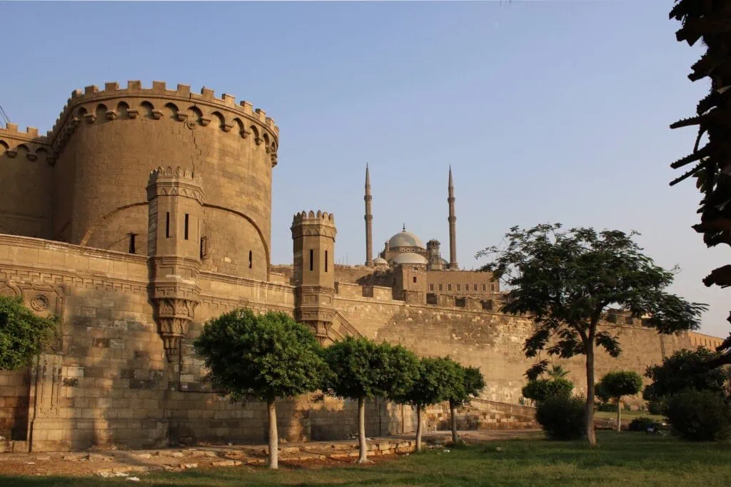 Exterior view of the fortified walls and round towers of the Citadel with the domes and minarets of the Mosque of Muhammad Ali in the background, Citadel of Salah El Din, Cairo