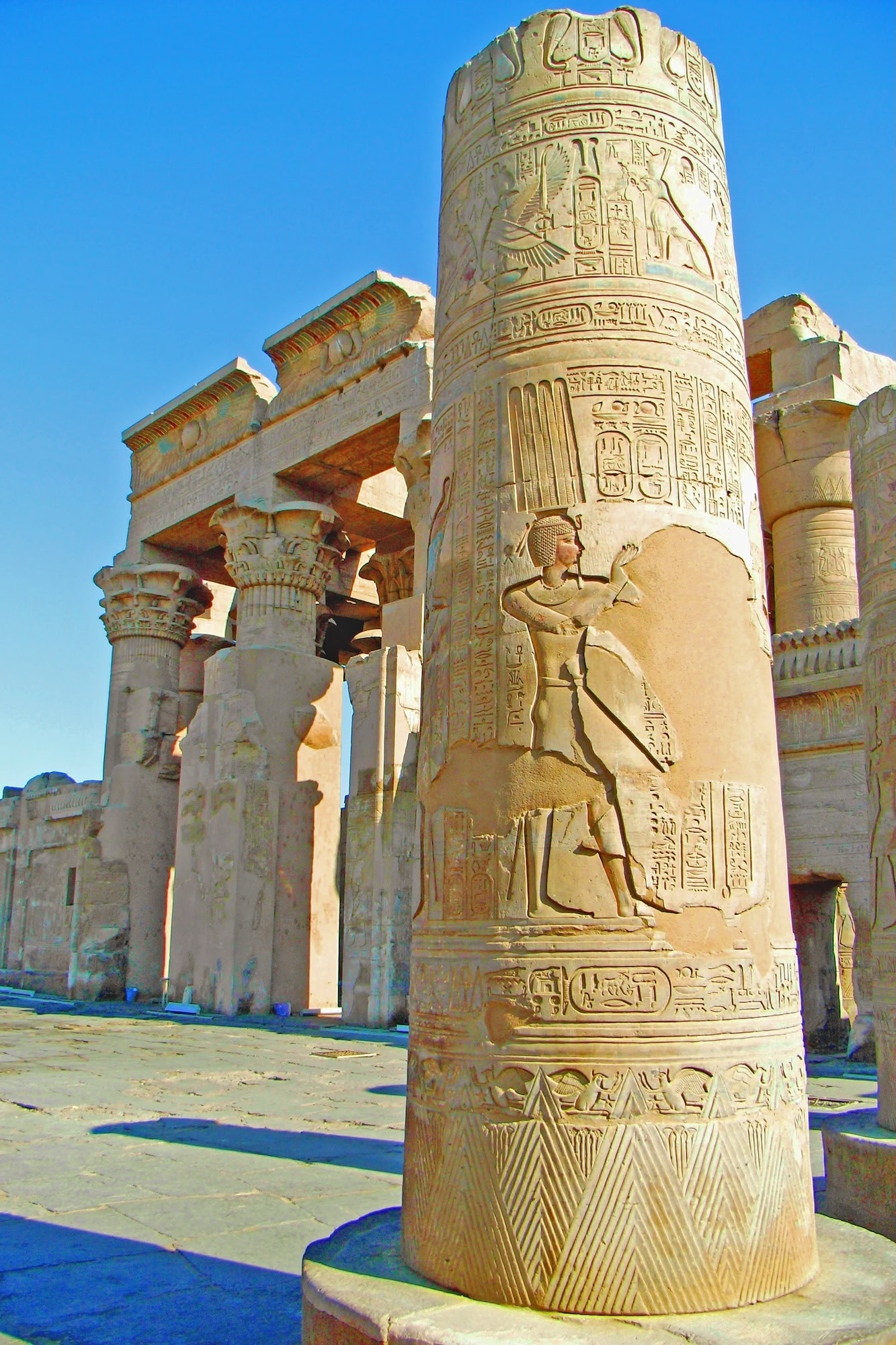 Ancient columns and hieroglyphic reliefs at Kom Ombo Temple showing carved pharaoh figure