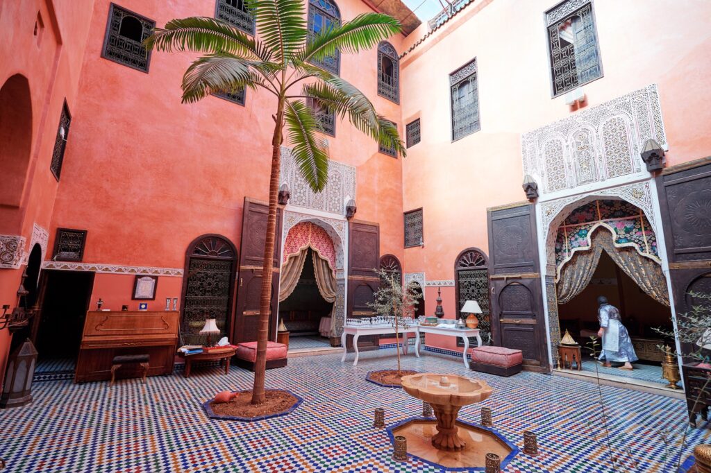 Traditional riad courtyard with central fountain, tiled walls, and surrounding arches, Marrakech