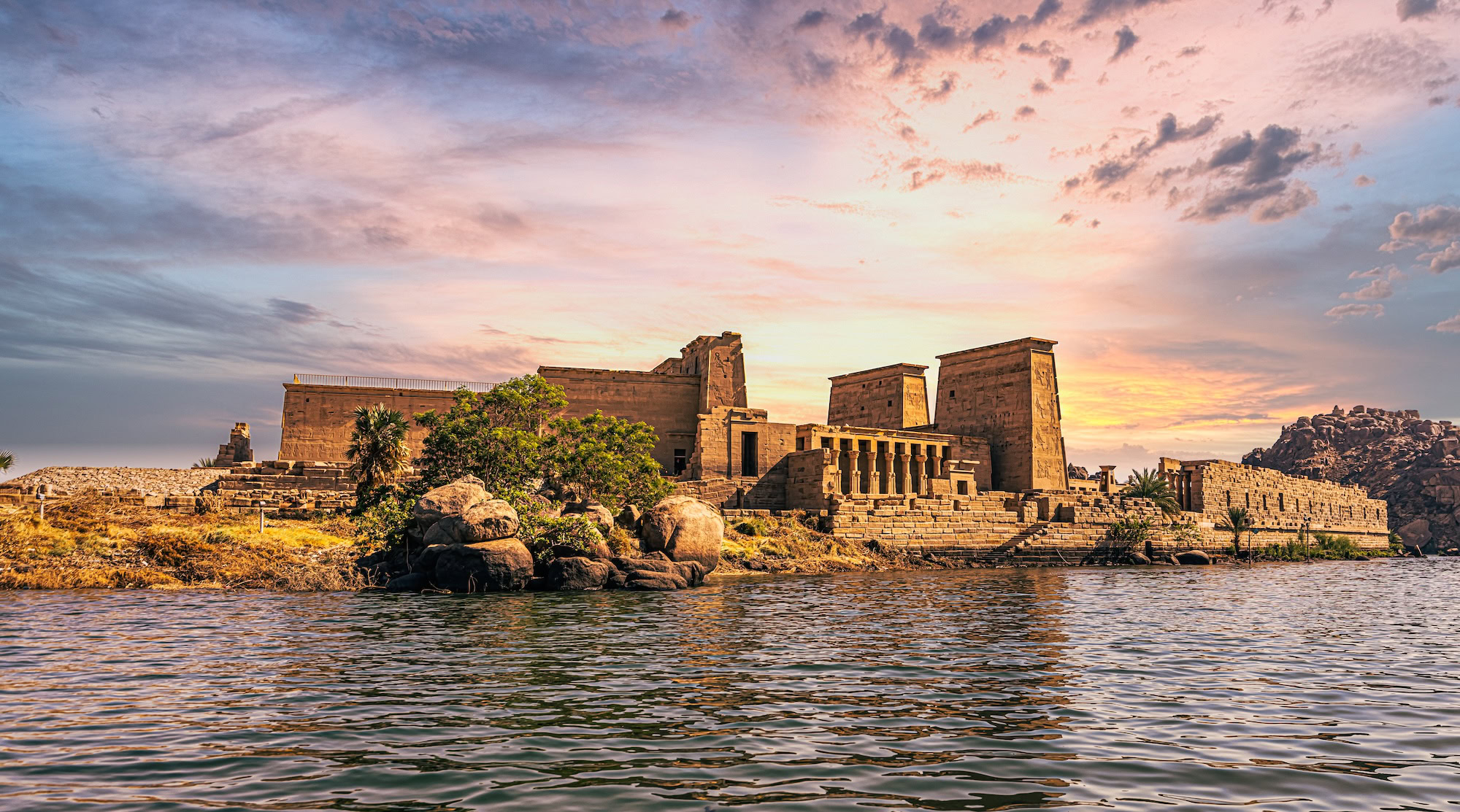 Temple of Philae in Aswan at sunset with ancient columns reflected in water