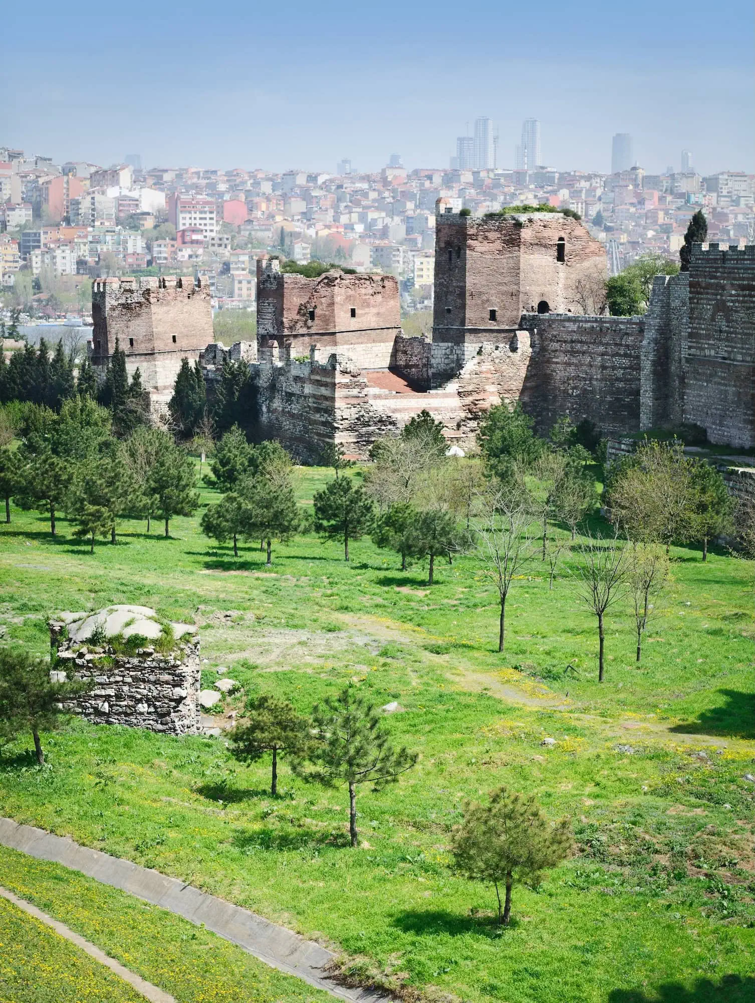 Ancient Byzantine fortress walls and towers in Istanbul with modern cityscape background
