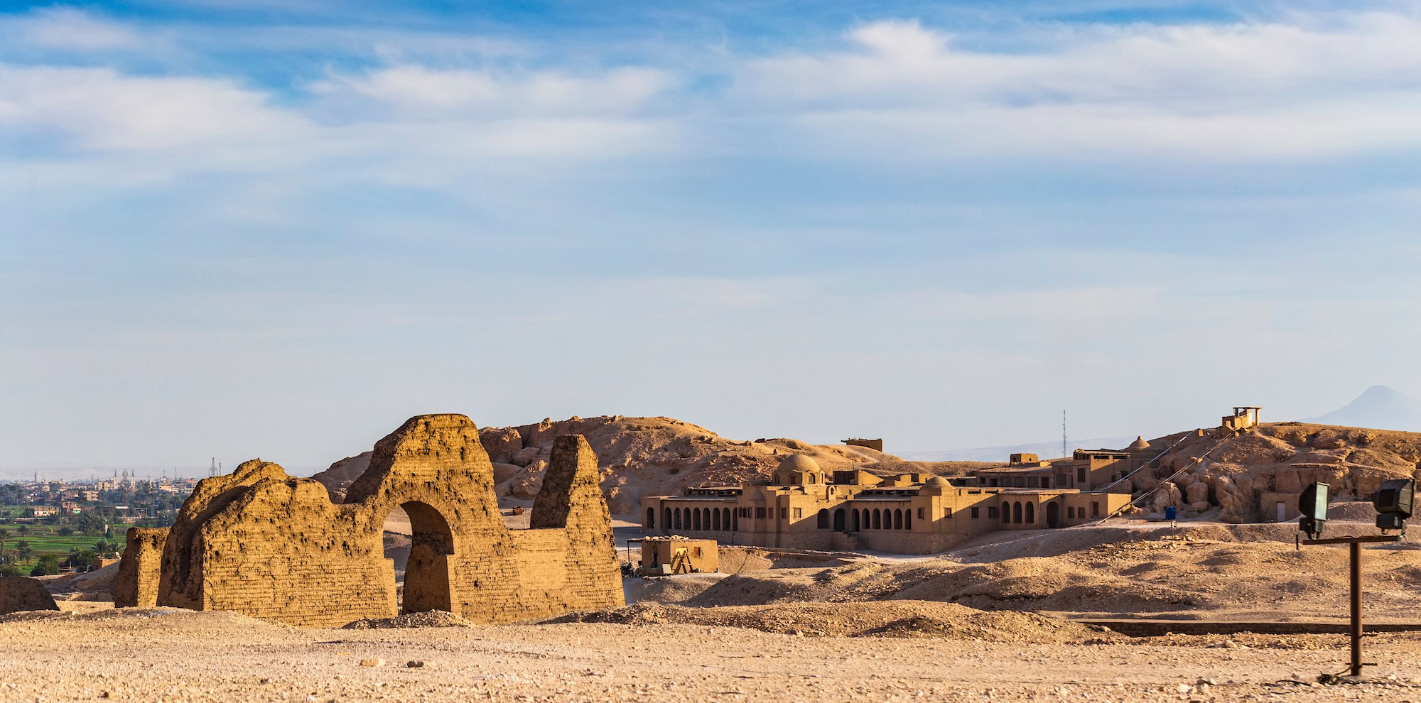 Ancient Egyptian archaeological site with mud brick ruins and arched doorways