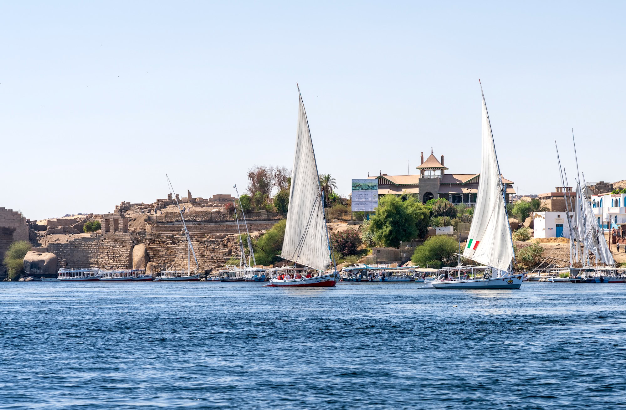 Ancient ruins on Elephantine Island with felucca sailboats on the Nile River in Aswan, Egypt