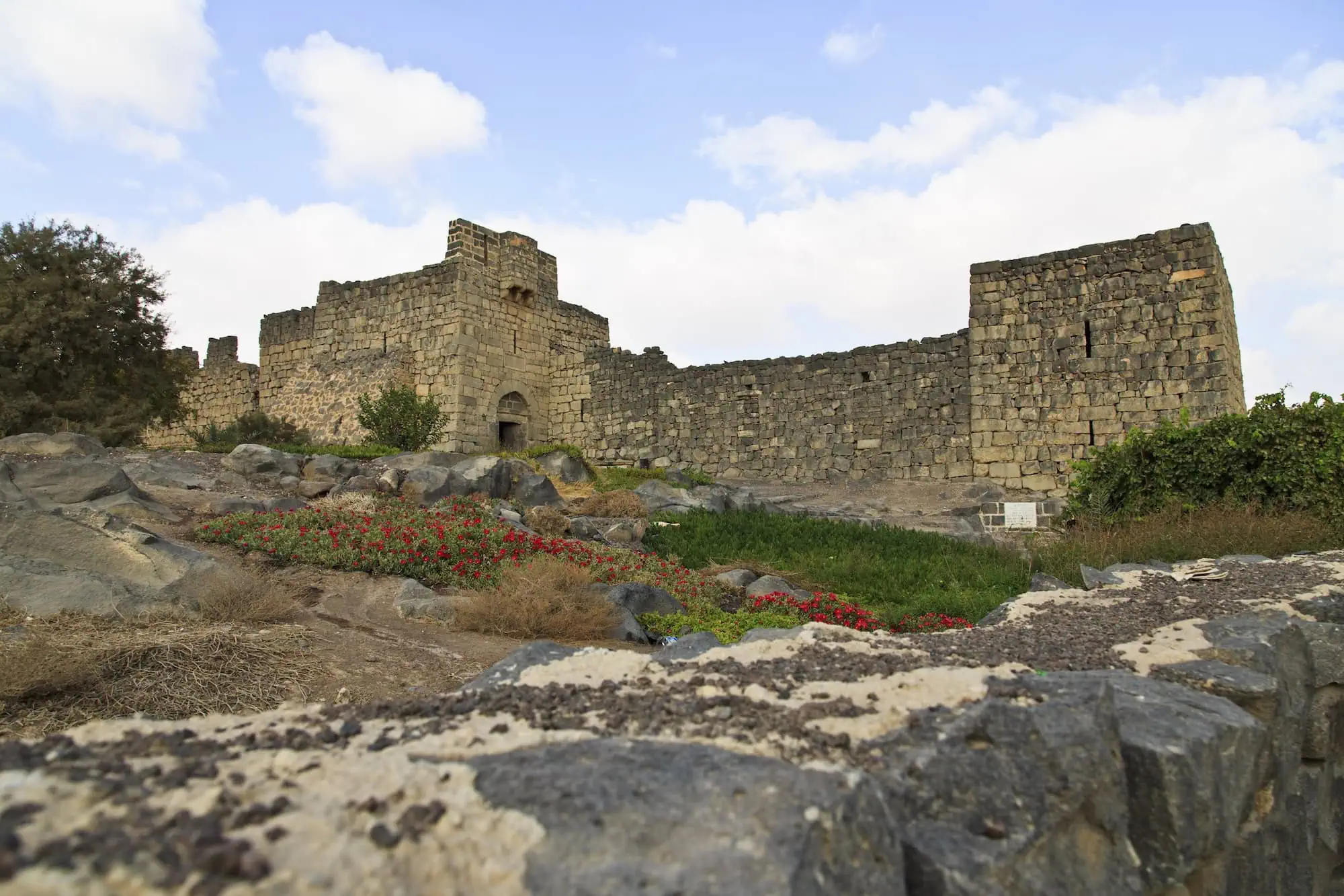 Ancient Azraq Castle ruins with dark volcanic basalt walls and scattered stones