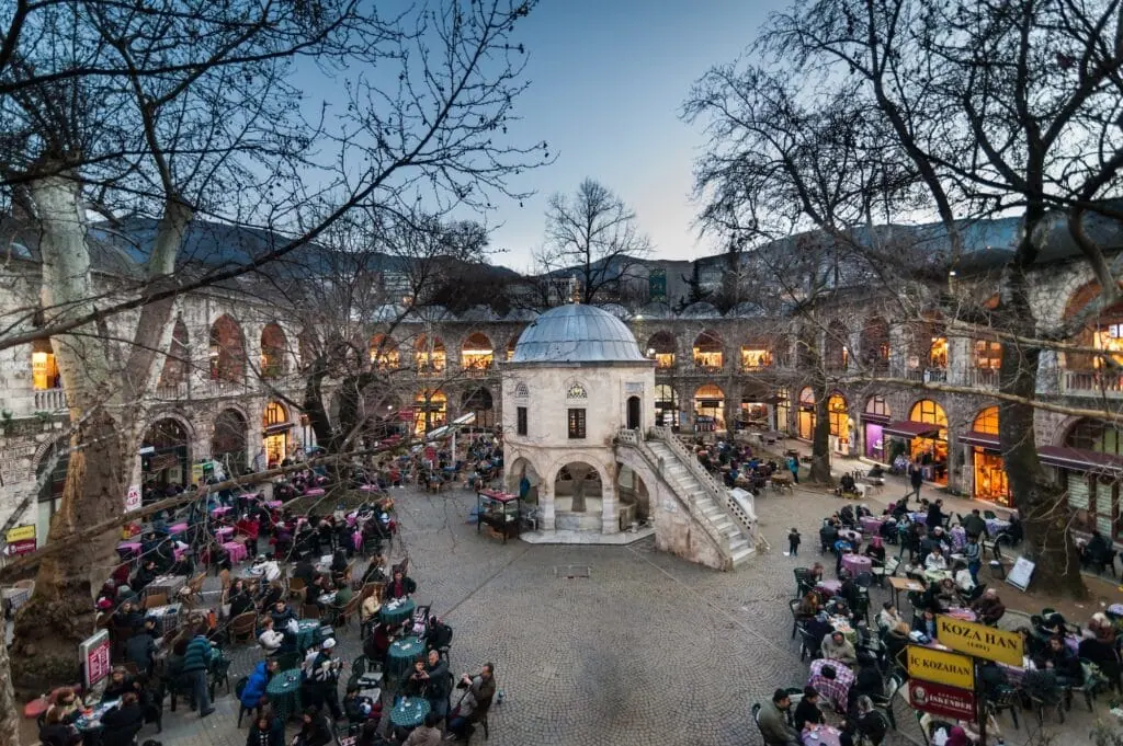 Tea gardens and small shops selling silk clothing and shawls in the courtyard of Koza Han Silk Bazaar, Bursa