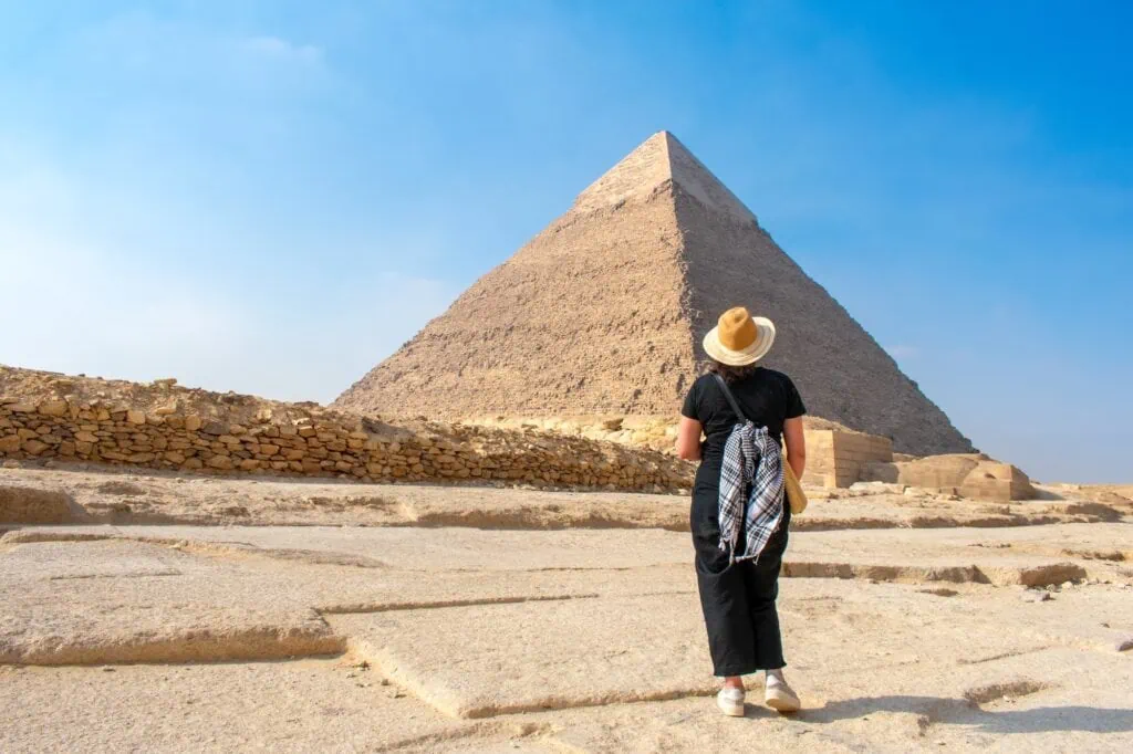 Back view of a woman facing the Pyramids of Khafre and Khufu at the Giza Plateau, Giza
