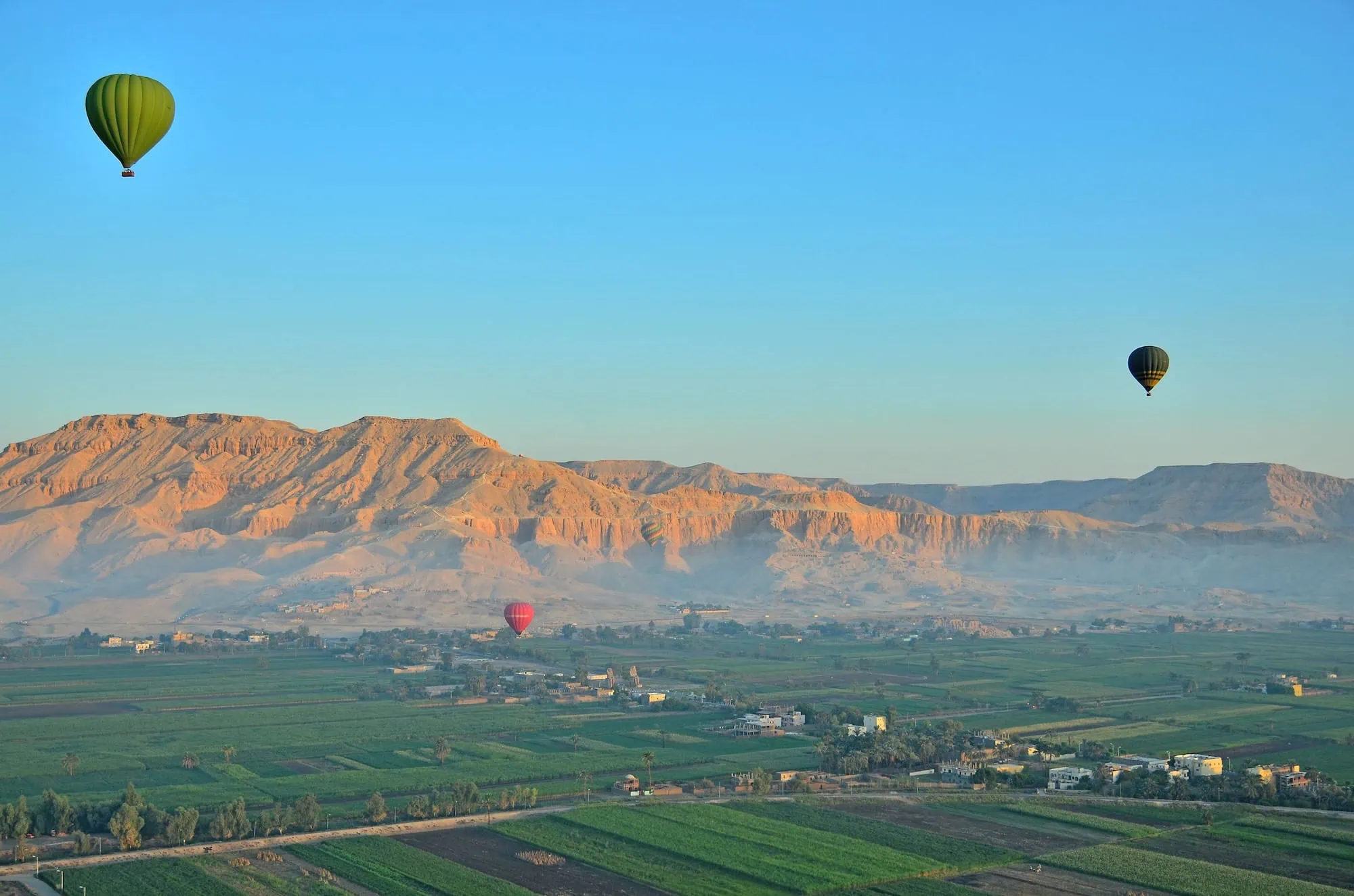 Vista aérea del Valle de los Reyes con globos aerostáticos sobre paisaje desértico