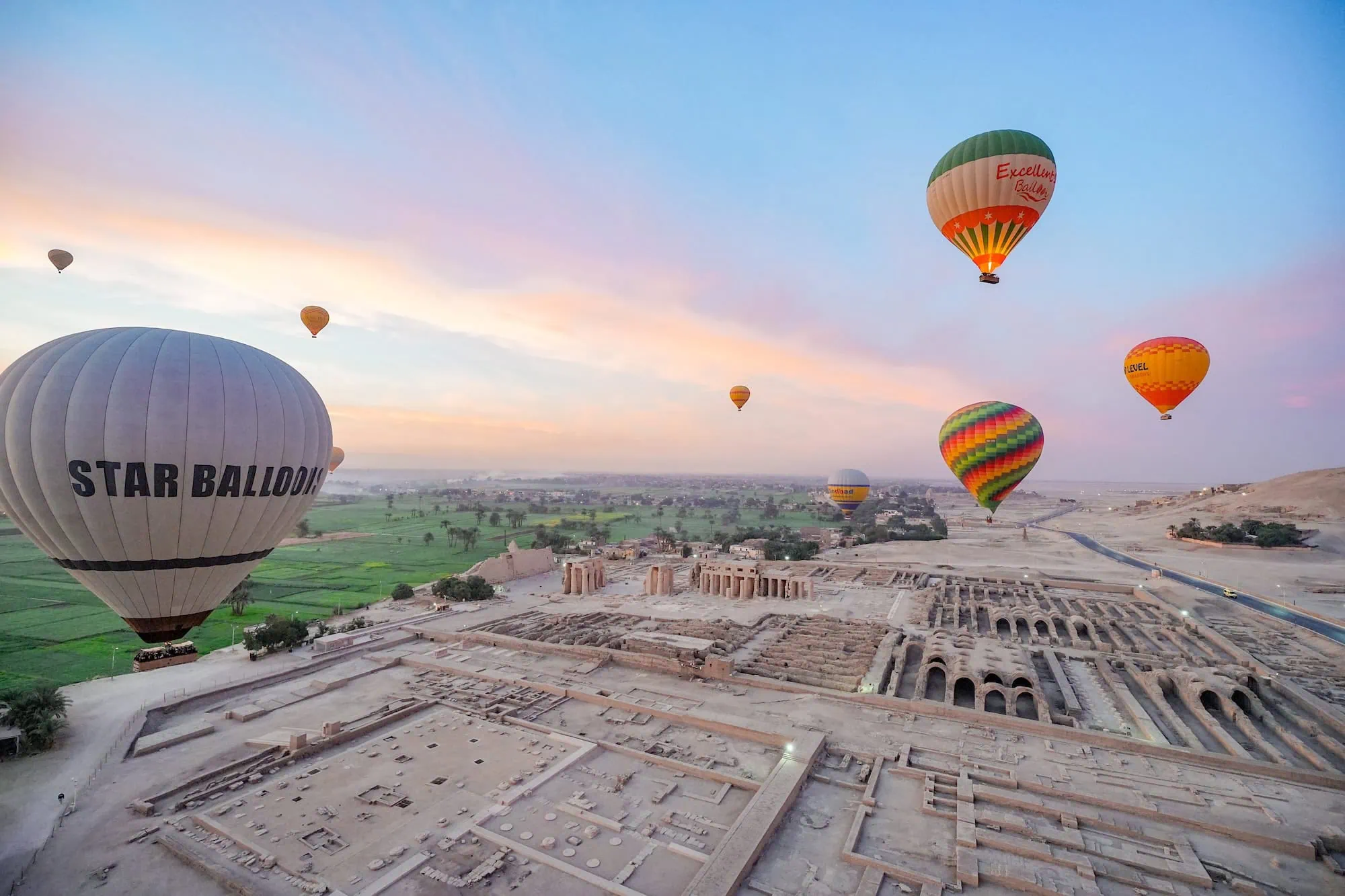 Hot air balloons floating over ancient Egyptian temple ruins in the Valley of the Kings, Luxor