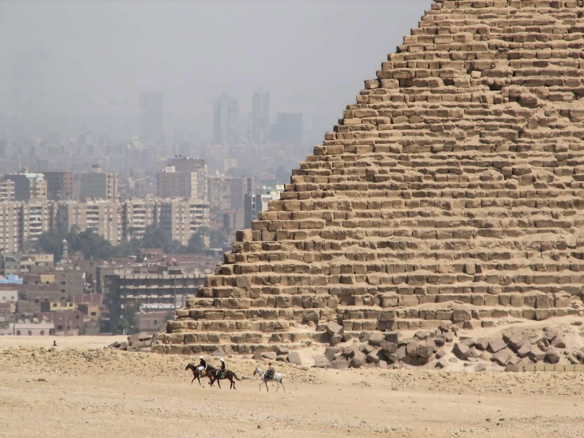 Gran Pirámide de Giza con camellos y jinetes en el desierto de El Cairo