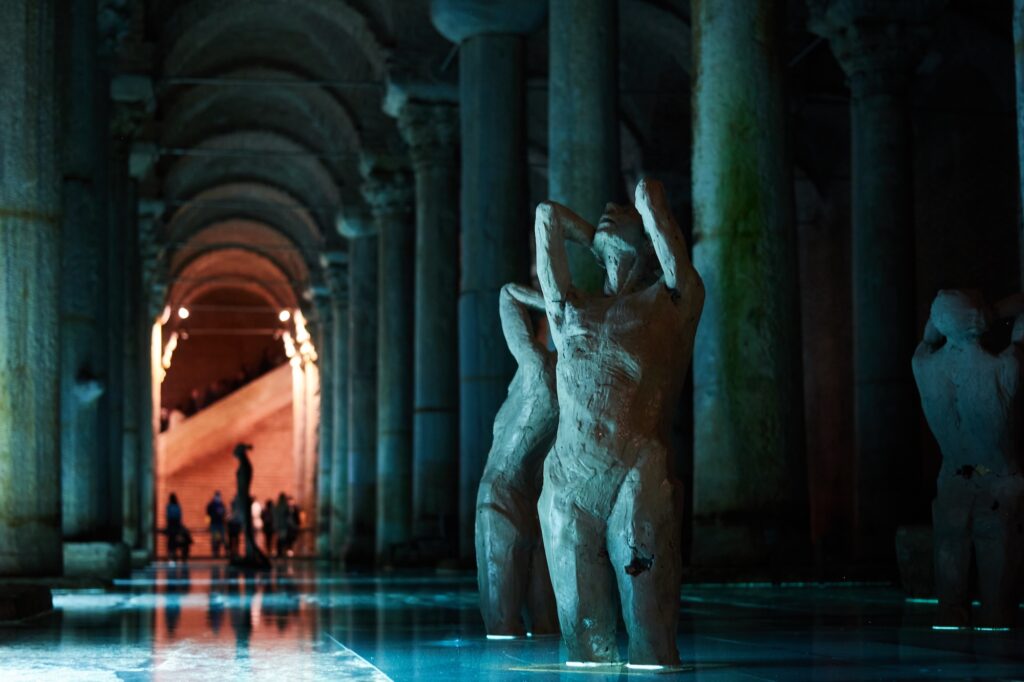 The marble statues are in the middle of a hallway.