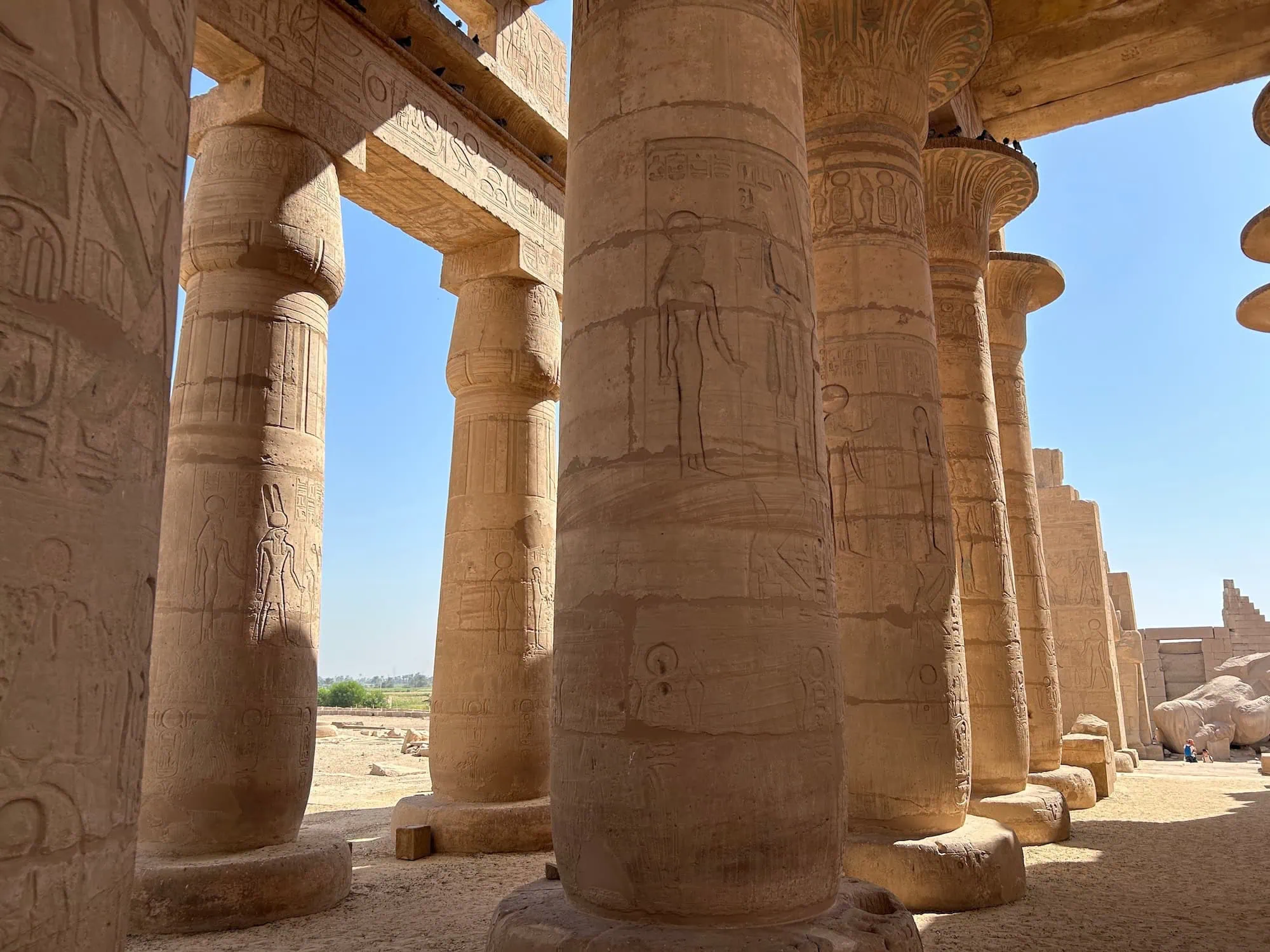 Impressive column hall at Karnak Temple with detailed hieroglyphic carvings on sandstone pillars
