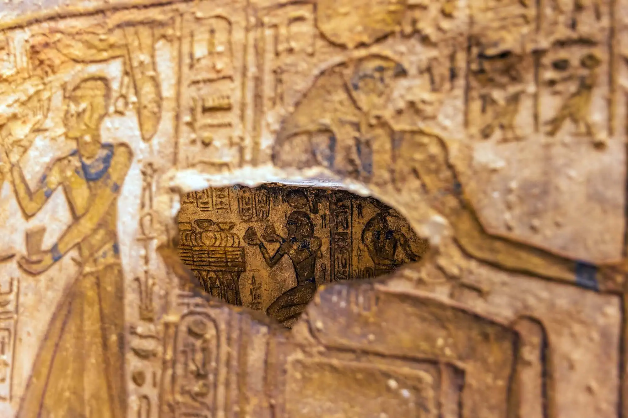 Ancient Egyptian tomb wall with hieroglyphics and painted figures depicting burial rituals