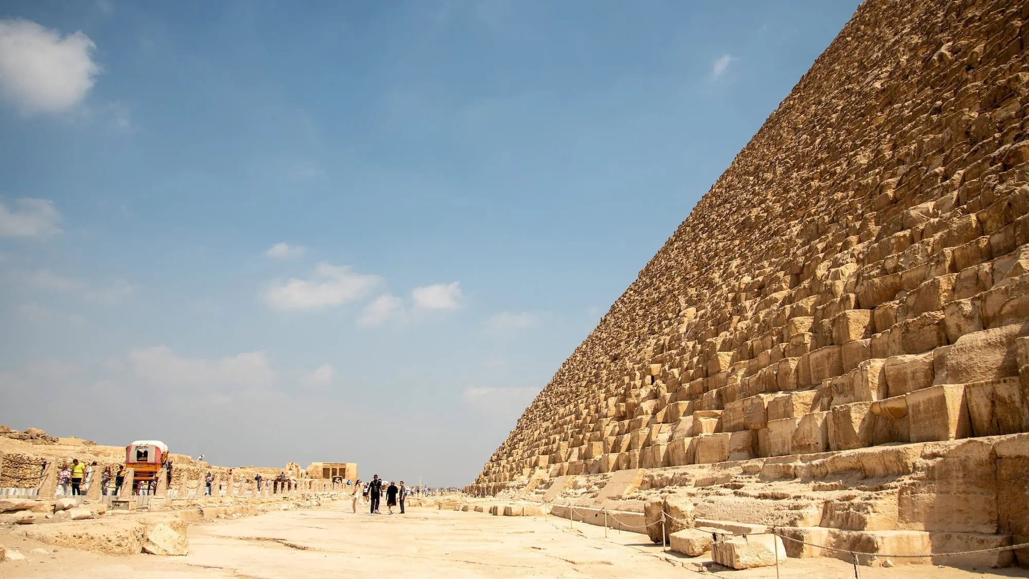 Tourists exploring the massive stone blocks of the Great Pyramid of Giza