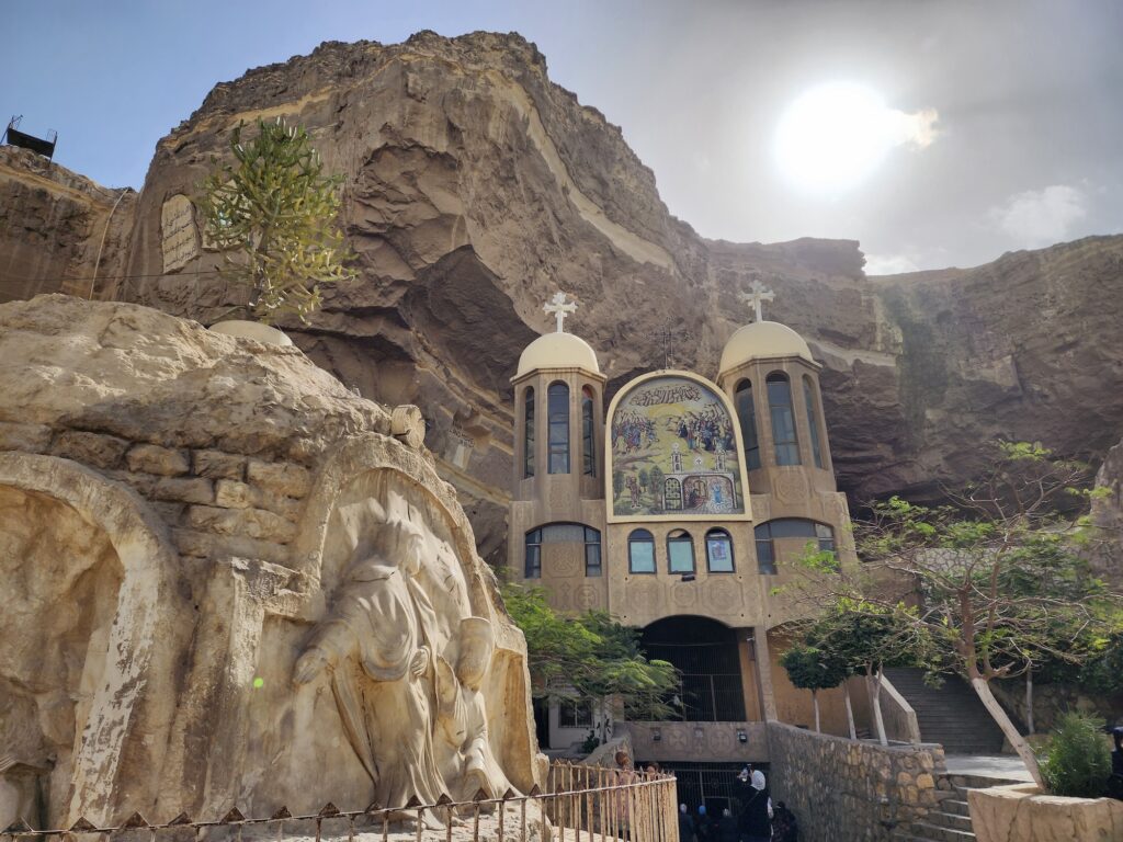 An exterior view of the rock-cut facade and cave entrance of Saint Simon the Tanner Church in the Mokattam hills, Cairo