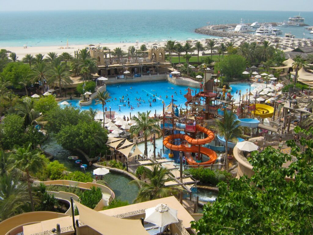 Beautiful view of Wild Wadi Waterpark. People swim in the pool and ride water attractions.