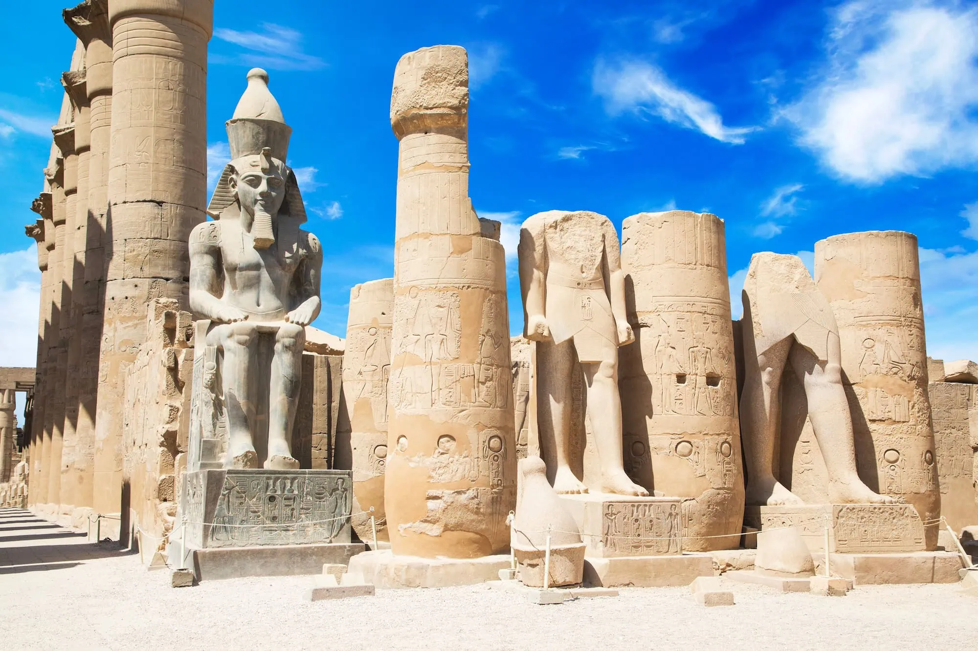 Ancient sphinx and pharaoh statues among hieroglyphic columns at Karnak Temple Complex in Luxor