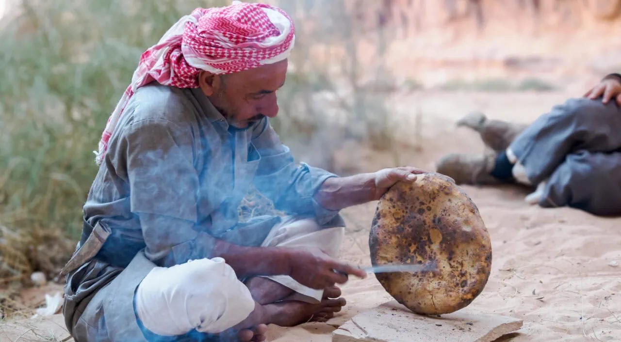 Bedouin makes Bedouin bread traditionally over a fire in the desert. Jordan