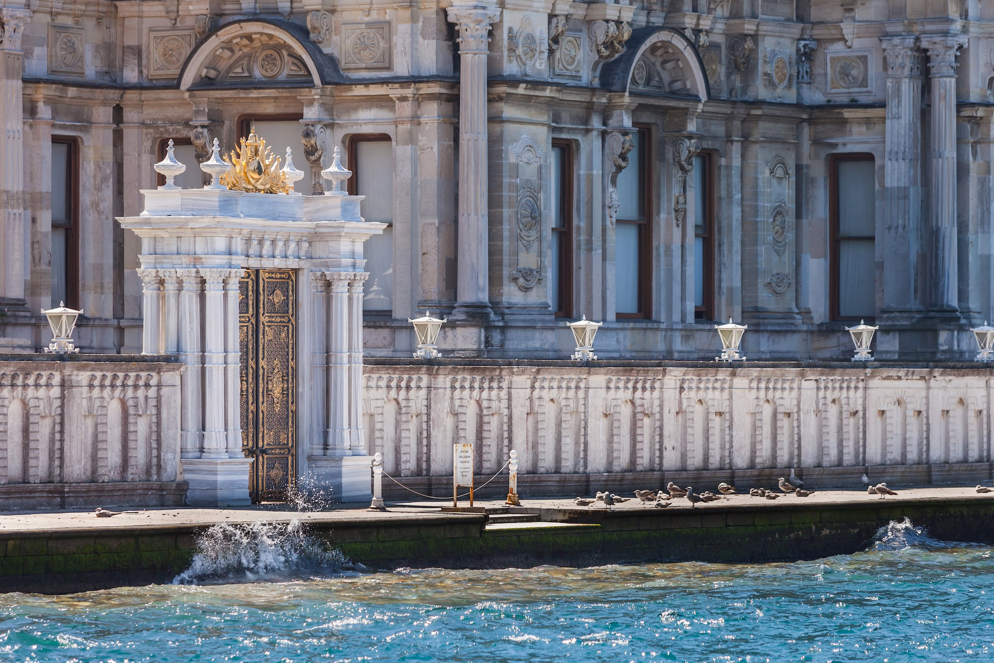 Ornate Dolmabahce Palace waterfront with baroque architecture and decorative columns