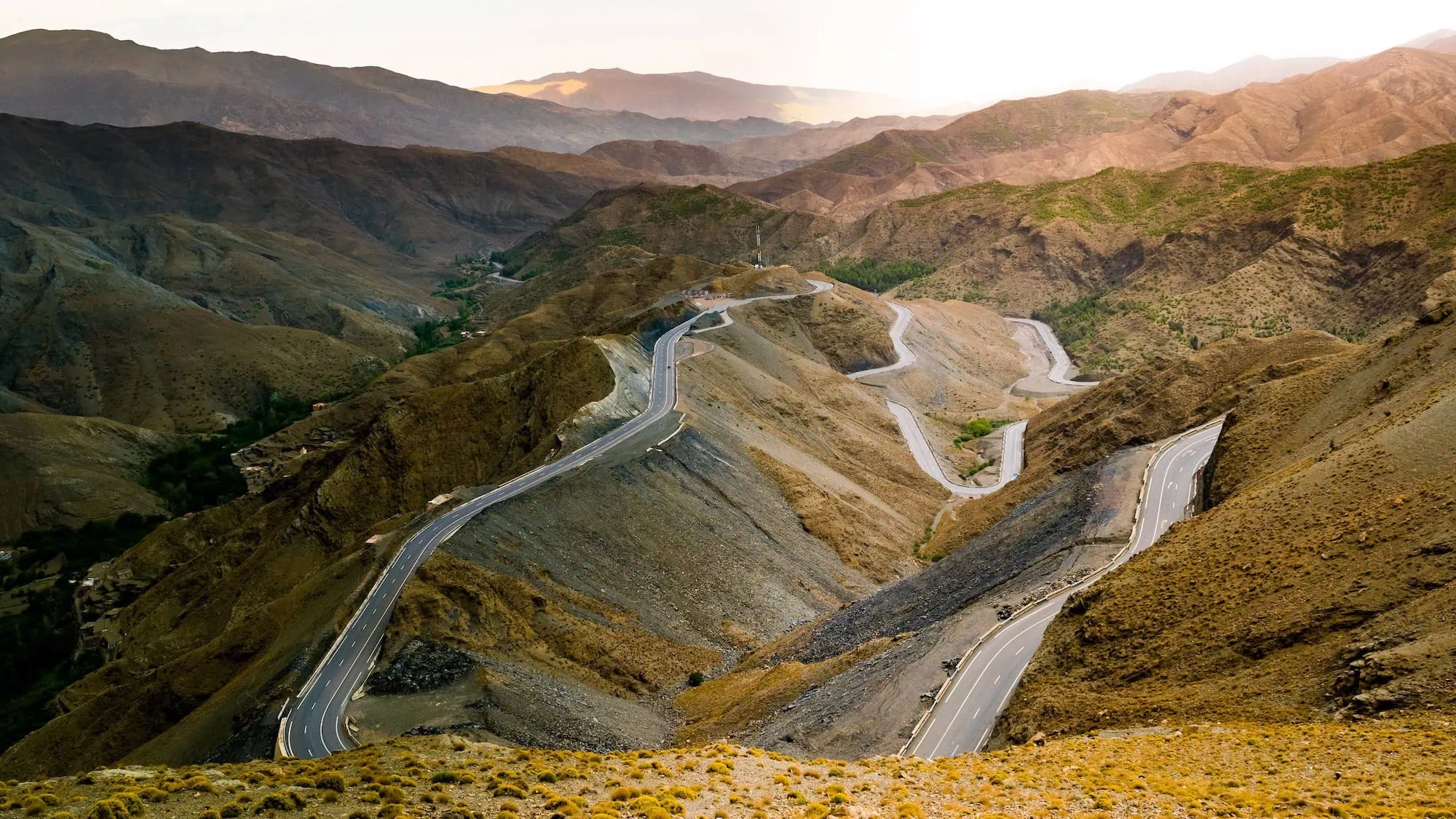 Winding mountain road through High Atlas Mountains with dramatic switchbacks and hairpin turns